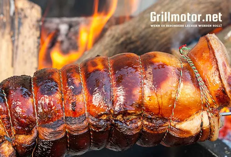 Spanferkel am Drehspieß über der Glut